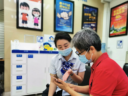 建行成都第六支行，大堂經(jīng)理為客戶(hù)介紹手機銀行“大字”模式